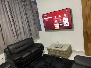 a living room with a leather recliner and a flat screen tv at Villa de Lujo con Picsina Privada in San Pedro de Macorís