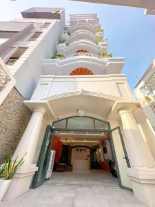 un grand bâtiment blanc avec une porte ouverte dans l'établissement Milan Homestay - Milanesa Hotel and Apartment, à Vung Tau