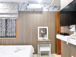 1 dormitorio con cama, espejo y lavamanos en Milan Homestay - Milanesa Hotel and Apartment, en Vung Tau