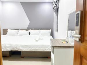 a bedroom with a bed with white sheets and pillows at Milan Homestay - Milanesa Hotel and Apartment in Vung Tau