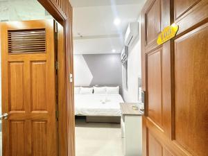 a door leading to a bedroom with a bed at Milan Homestay - Milanesa Hotel and Apartment in Vung Tau