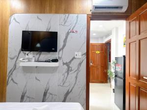 a bedroom with a marble wall with a tv on it at Milan Homestay - Milanesa Hotel and Apartment in Vung Tau