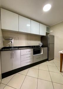 une cuisine avec des appareils électroménagers en acier inoxydable et des armoires blanches dans l'établissement Quartier Administratif, à Tetouan