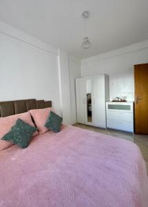 a bedroom with a large pink bed with two pillows at Quartier Administratif in Tetouan