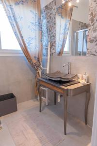 uma casa de banho com uma mesa de madeira e um lavatório em Gerani Apartments em Bordighera
