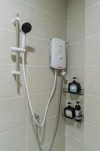 a shower with a hair dryer and a tv in a bathroom at SUMMER SUITES APARTMENT CASETTA HOMESTAY 1 at Kota Samaraham Kuching in Kota Samarahan