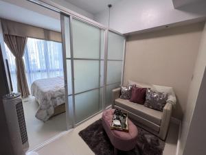una pequeña sala de estar con sofá y cama en 38 Park Avenue Condominium Cebu IT Park - Unit Freyja en Cebú