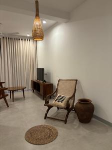 uma sala de estar com uma cadeira de baloiço e uma televisão em Sea Esta Villa Mount Lavania em Ratmalana