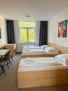 Cette chambre comprend 4 lits et une fenêtre. dans l'établissement Apartmánový byt, à Valašské Meziříčí