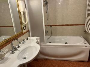 La salle de bains est pourvue d'une baignoire, d'un lavabo et d'une douche. dans l'établissement 039 Maggioni B&B, à Montevecchia