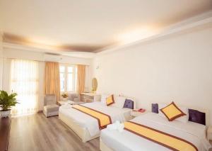 a hotel room with two beds and a couch at Mercury Hotel & Apartment in Vung Tau