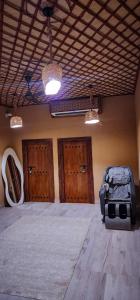a room with three wooden doors and a suitcase at Aldar Inn in Nizwa