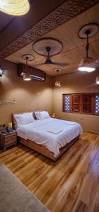 1 cama grande en un dormitorio con suelo de madera en Aldar Inn, en Nizwa