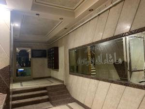 a lobby with a staircase and a wall with writing on it at Deluxe Apartment Nasr city in Cairo