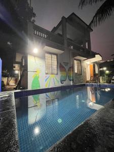 a swimming pool in front of a house at night at Ladakh House- 3 BHK Ladakh themed Villa near Matheran in Neral