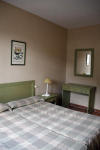 a bedroom with a bed and a table and a mirror at Villa Turística de Grazalema in Grazalema