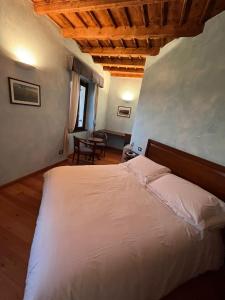 een slaapkamer met een wit bed en een tafel bij 039 Maggioni B&B in Montevecchia