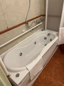 een badkamer met een wit bad en een douche bij 039 Maggioni B&B in Montevecchia
