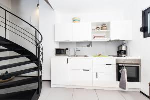 a kitchen with white cabinets and a spiral staircase at Villa Sun House - Happy Rentals in Dragove