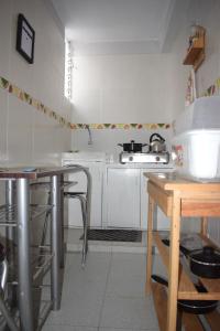una pequeña cocina con armarios blancos y una mesa en El Valle Lunahuaná, en Lunahuaná