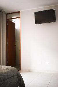El Valle Lunahuaná في لوناهوانا: غرفة نوم مع سرير وتلفزيون بشاشة مسطحة على الحائط