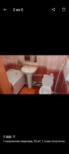 Un baño con bañera, inodoro y lavabo. en Квартира, en Uralsk