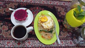 a green plate of food and a cup of coffee at Neny's Homestay in Saba