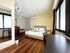 ein Schlafzimmer mit einem Bett und einem Tisch darin in der Unterkunft Madras Inn 58-1 Private Bathroom in George Town