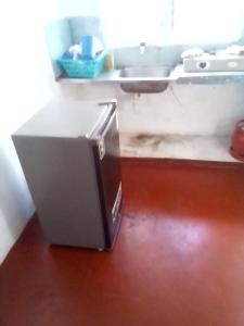 einen Kühlschrank auf dem Boden in einer Küche in der Unterkunft Gemütlich Green house in Mombasa