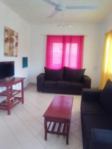 een woonkamer met een bank en een tafel bij Gemütlich Green house in Mombasa