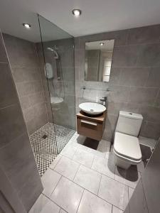 a bathroom with a toilet and a sink and a shower at Spacious Central 2Bed Apartment in Wilmslow
