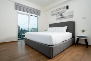 a bedroom with a large bed and a large window at Hotel Style Colombo Studio Apartment in Colombo