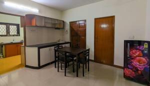 a kitchen with a table and chairs in a room at GKV Service Apartment Saligramam in Chennai