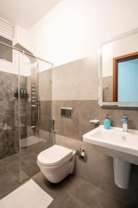 a bathroom with a toilet and a sink and a shower at La Privé Apartments Havelock in Colombo