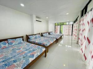 VMJ Inland Resort في Tagum: صف من الاسرة جالسة في غرفة