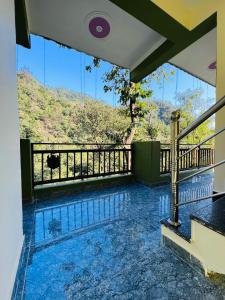 einen Blick vom Balkon eines Hauses mit Pool in der Unterkunft Shiv Shakti Yogpeeth Cottages in Rishikesh