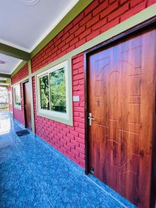 Shiv Shakti Yogpeeth Cottages في ريشيكيش: جدار من الطوب الأحمر مع باب مرآب خشبي