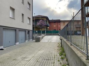uma rua vazia com uma cerca e edifícios em Lisonino House em SantʼAngelo Lodigiano