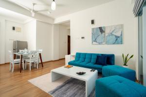 sala de estar con sofá azul y mesa en Hotel Style Colombo Studio Apartment en Colombo