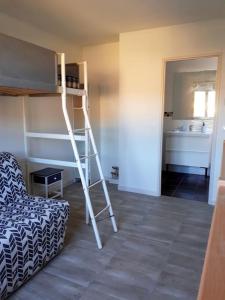 a room with a bunk bed with a ladder and a chair at Duplex 5 p 40m2 jardin de 50m2 in Six-Fours-les-Plages