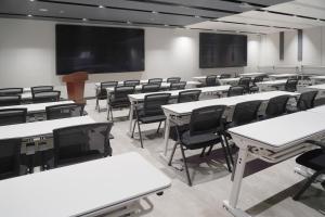 an empty classroom with white tables and chairs at Ibis Styles Hotel - 260M from Guangji Street Subway Station in Xi'an