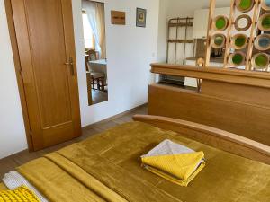a bedroom with a bed with a yellow blanket on it at Samoobslužný hotel Vydra in Srní