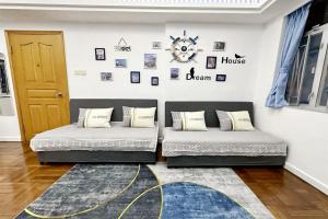 two beds in a room with a door and a rug at Fantastic Queen beds, 4Rms beside MTR grand 14ppls 2 bathrm in Hong Kong