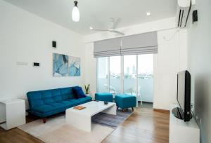 a living room with a blue couch and a tv at Hotel Style Colombo Studio Apartment in Colombo