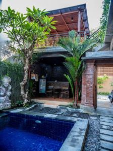 a house with a swimming pool in the yard at The Ganesha Homestay in Canggu