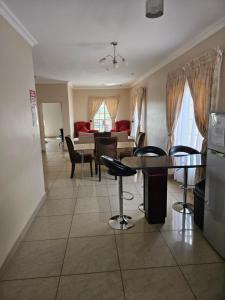 eine Küche und ein Wohnzimmer mit einem Tisch und Stühlen in der Unterkunft Booth Suite Hotel Mafikeng in Mahikeng