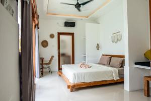 um quarto com uma cama e uma ventoinha de tecto em KIKI VILLAGE PADDY FIELD em Canggu