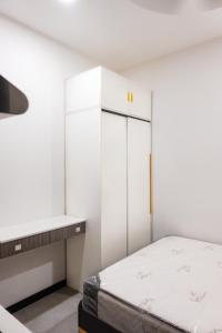 a white bedroom with a bed and a desk at Ampang Neu Suites by DreamOak in Kuala Lumpur