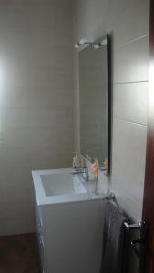 y baño con lavabo blanco y espejo. en Villa Antonieta, en Denia
