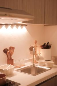 a kitchen counter with a sink and a counter top at Ampang Neu Suites by DreamOak in Kuala Lumpur